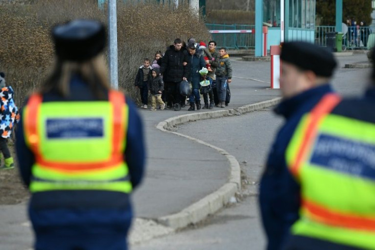 A Ukrainian refugee family with young children and other Ukrainians arrive at the border after fleeing the Russian invasion