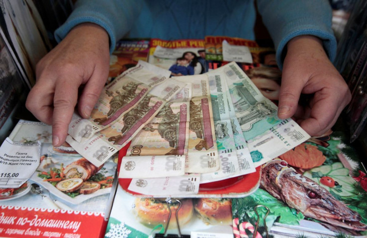 The vendor of a newspaper and magazine stall demonstrates rouble banknotes in Stavropol, southern Russia, January 21, 2016. 