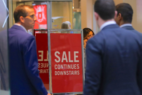 Shoppers walk through a shopping centre past a retail store displaying a sale sign in central Sydney, Australia, November 1, 2017. 