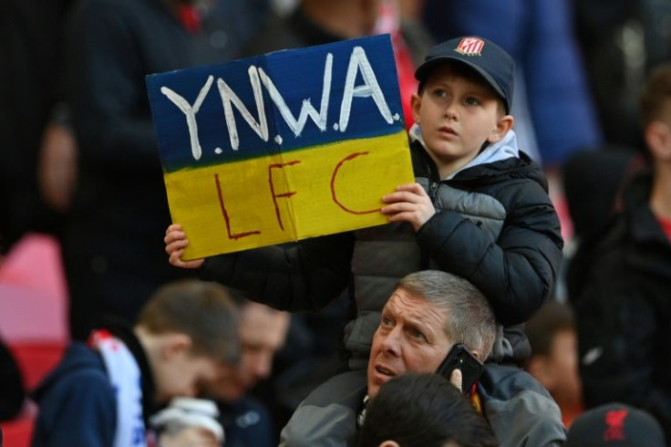 Support: A young Liverpool fan holds up a placard in the Ukrainian colours saying 'You'll never walk alone' at Wembley