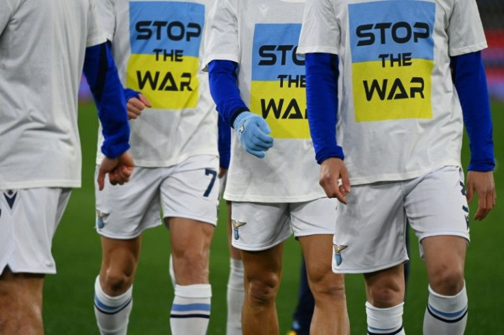Lazio team players wear a 'Stop the war' T-shirts referring to Russia's invasion of the Ukraine as they arrive to warm-up prior to the Italian Serie A football match between Lazio and Napoli at the Olympic stadium, in Rome