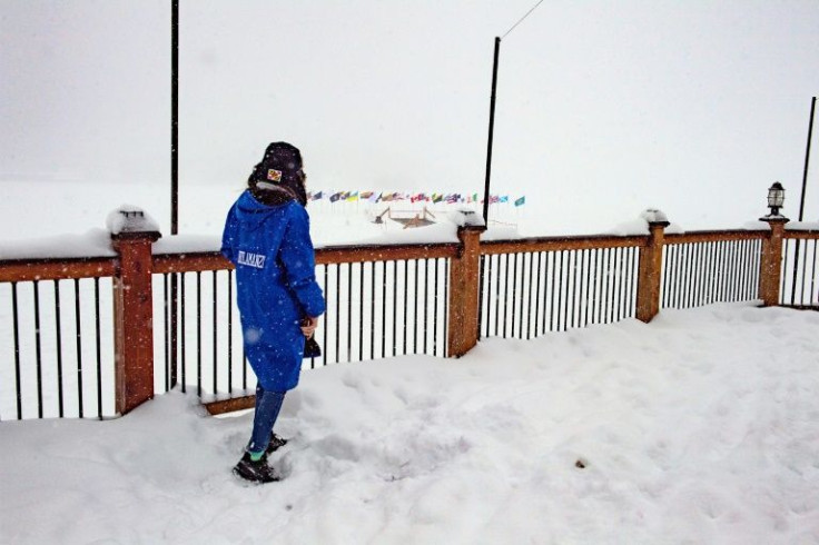 A swimmer looks out over the frozen landscape from a lakeside deck and the 75-foot pool she will swim in during the Memphremagog Winter Swim Festival in Newport, Vermont on February 25, 2022