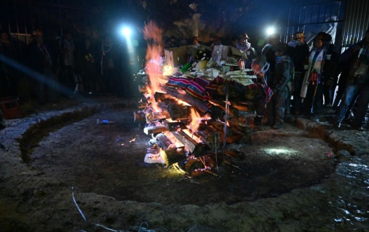 The ritual ends with miners burning offerings packed out on large tables
