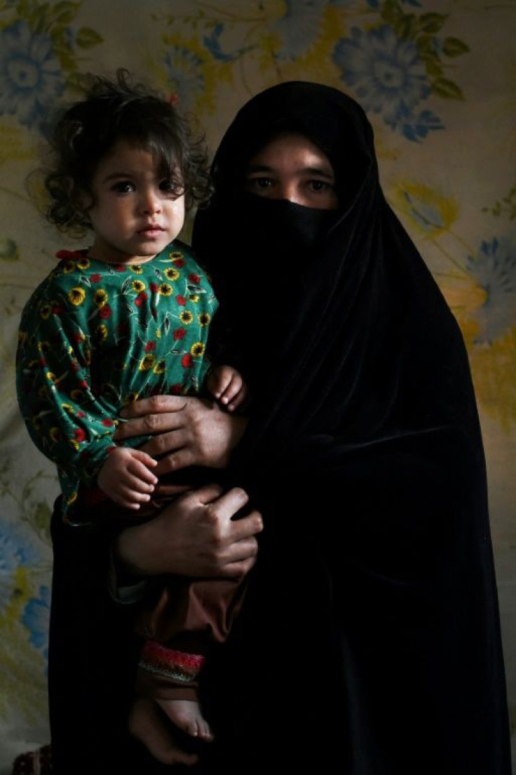 Aziza, who plans to sell her kidney to raise money for her family, poses for a picture with her daughter Parwina at her house in Herat