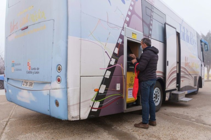 A man withdraws money at a cashpoint set up in a library bus in Anover de Tormes