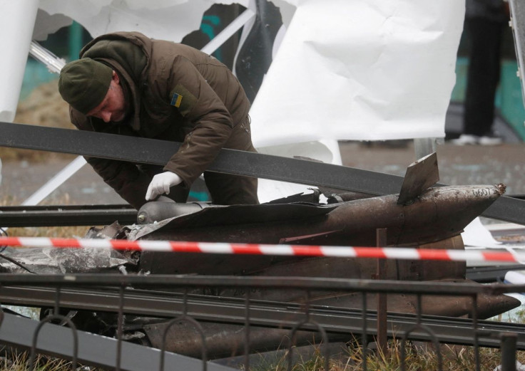 A police officer inspects the remains of a missile that landed in the street, after Russian President Vladimir Putin authorized a military operation in eastern Ukraine, in Kyiv, Ukraine February 24, 2022. 