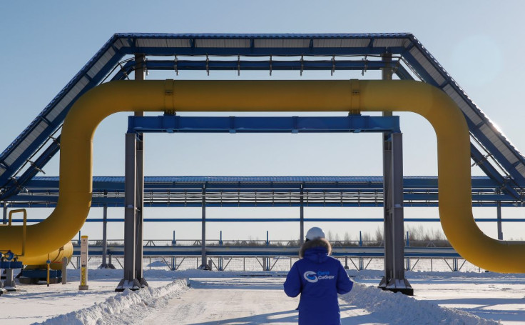 An employee in branded jacket walks past a part of Gazprom's Power Of Siberia gas pipeline at the Atamanskaya compressor station outside the far eastern town of Svobodny, in Amur region, Russia November 29, 2019. 