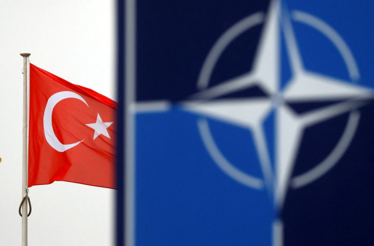 A Turkish flag flies next to NATO logo at the Alliance headquarters in Brussels, Belgium, November 26, 2019.