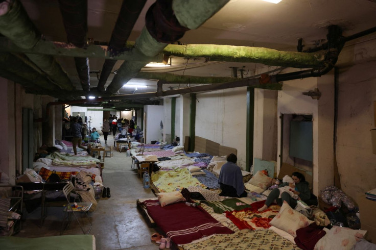 A woman sits next to a child patient whose treatments is underway, in the hallways of basement floors of Okhmadet Children's Hospital, as Russia's invasion of Ukraine continues, in Kyiv, Ukraine February 28, 2022.