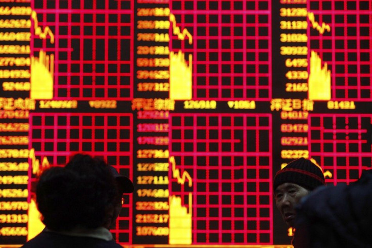 People look at an electronic board at a brokerage house in Shanghai