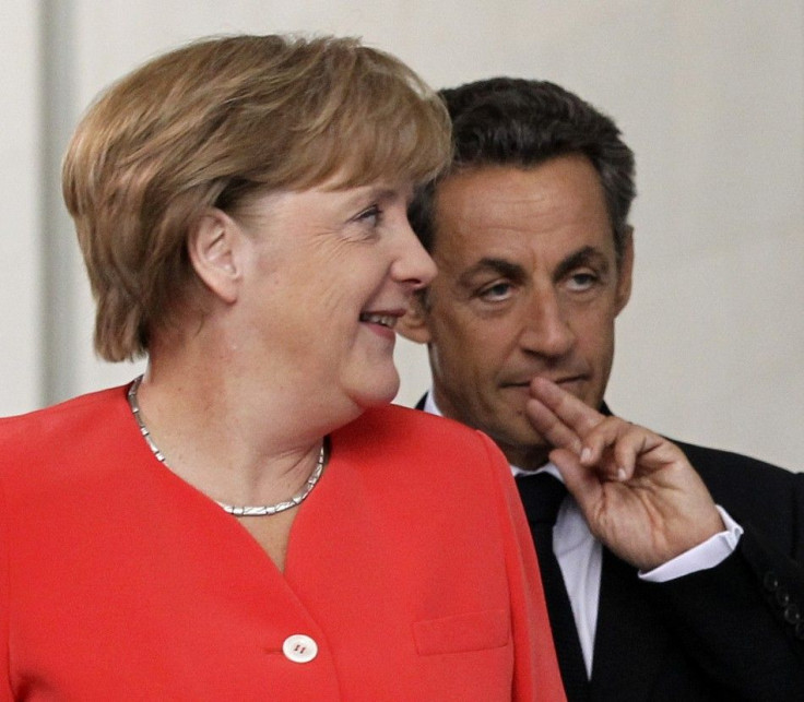French President Sarkozy and German Chancellor Merkel arrive to address a news conference at the Chancellery in Berlin