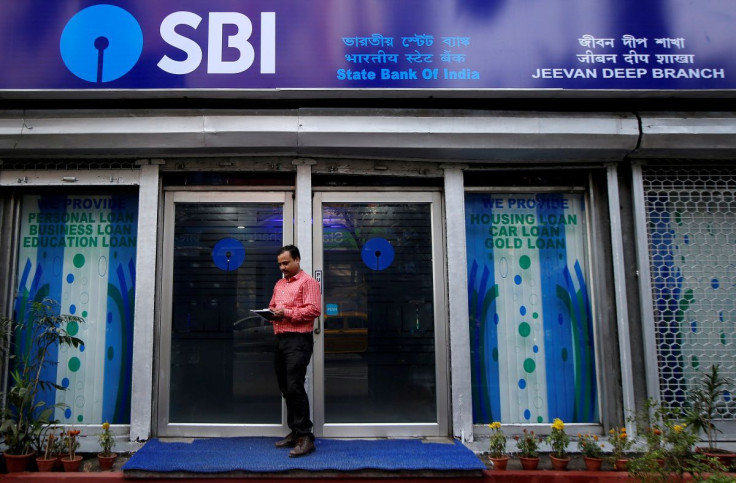 A man checks his mobile phones in front of State Bank of India (SBI) branch in Kolkata, India, February 9, 2018.