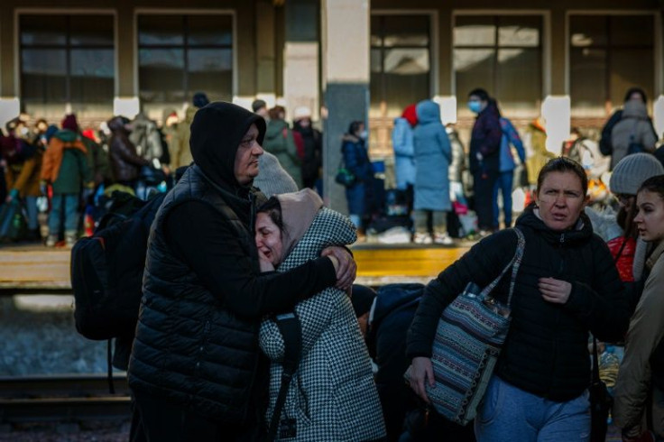 A man hugs his wife before she boards an evacuation train at Kyiv's central train station