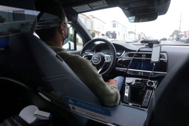 A safety operator is seen in the front seat of a self-driving Waymo vehicle in San Francisco, California, U.S. August 20, 2021. Picture taken August 20, 2021. 