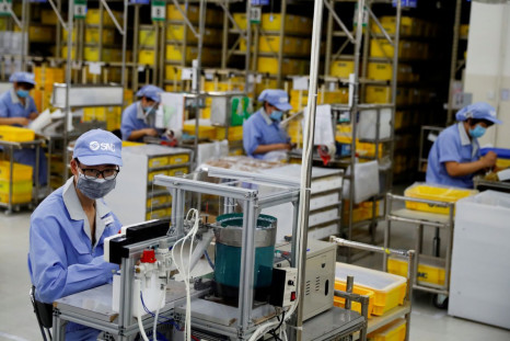 Employees wearing face masks work at a factory of the component maker SMC during a government organised tour of its facility following the outbreak of the coronavirus disease (COVID-19), in Beijing, China May 13, 2020. 
