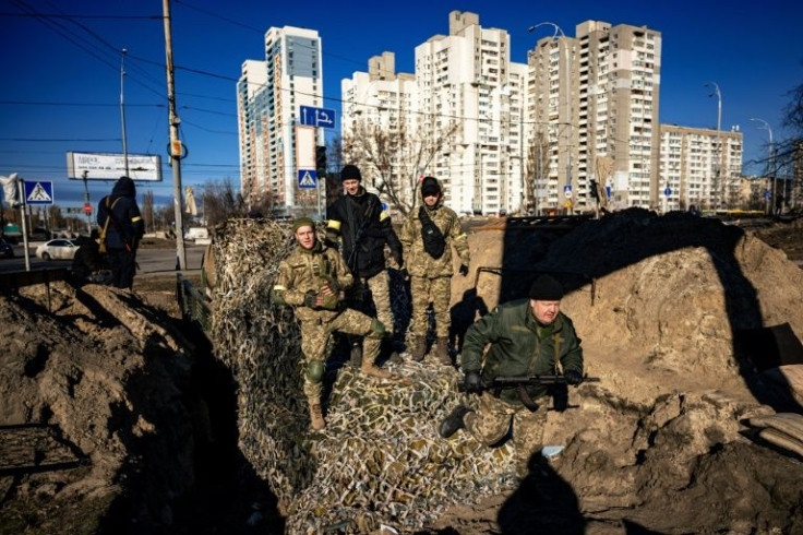 In Kyiv, makeshift barricades dot the streets and residents form long queues outside the few shops with essentials that remain open