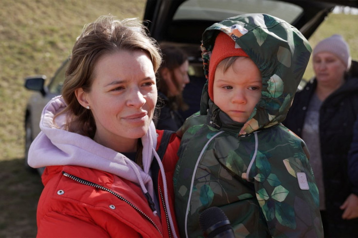 Svetlana, 28, a Ukrainian woman from Kyiv, stands with her son Semyon as they arrive at the Hungarian border village of Tiszabecs, Hungary March 1, 2022 in this still image taken from a video. Gergely Papai/REUTERS TV via REUTERS