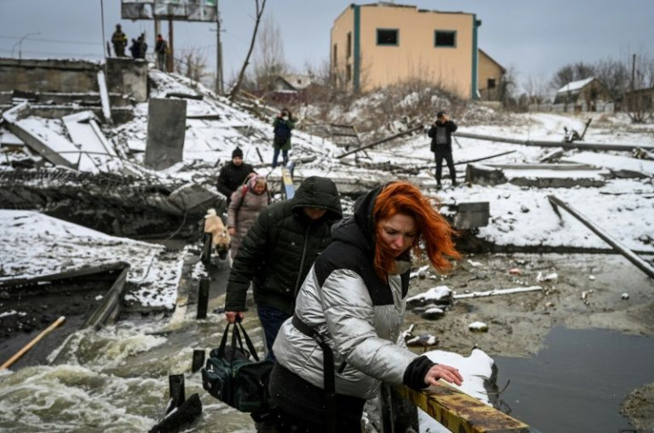 Civilians cross a river on a blown-up bridge on Kyiv's northern front on March 1