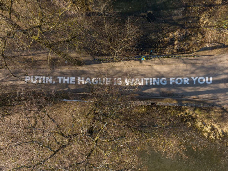 A sign that reads âPutin, the Hague is waiting for youâ is seen outside the Russian embassy in Vilnius, Lithuania on February 28, 2022.  Vilnius Municipality/Handout via REUTERS