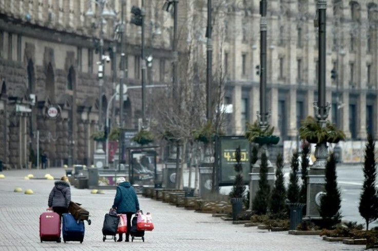 Women drag luggage in the deserted streets of Ukrainian capital Kyiv on March 1, 2022 as fears grow of an all-out assault by Russian forces