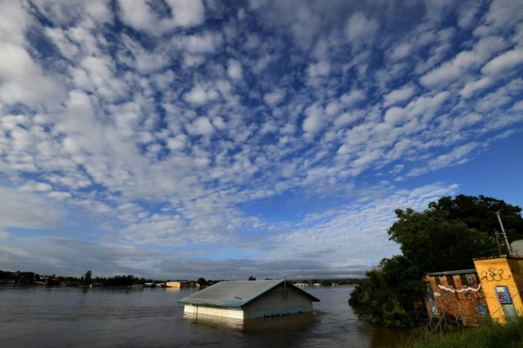 Floodwaters crashed into more towns on Australia's east coast as a deadly storm front barrelled south on Wednesday towards Sydney, where the main dam began to spill water