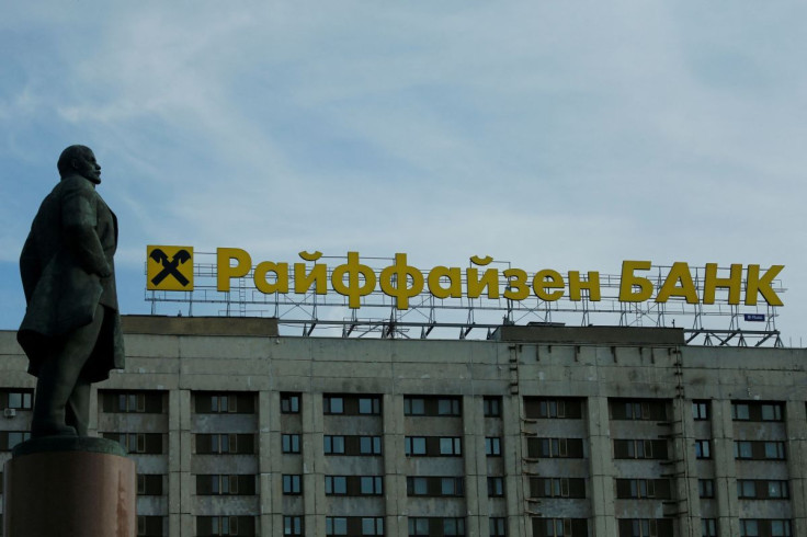 The logo of Raiffeisen Bank on top of a building is seen behind a statue of Soviet state founder Vladimir Leninin Moscow, Russia, June 14, 2016. 