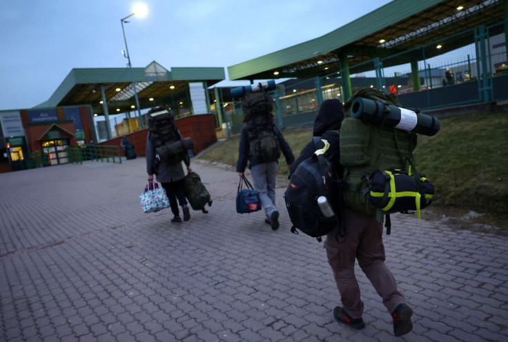 Ukrainian men carry their equipment towards the border as they return to Ukraine to fight the Russian invasion, at the border checkpoint in Medyka, Poland, March 2, 2022.