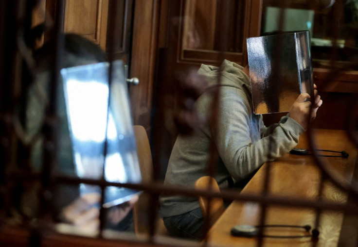Two brothers, suspected of murdering their sister for not submitting to the moral standards of the family coming from Afghanistan, according to the prosecutor, cover their faces at the main hearing, at the higher regional court, in Berlin, Germany, March
