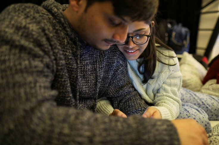 Ritika Pandey, 20, and Bhanu Pratap Sigriwal, 21, watch news updates on a smartphone after fleeing the Russian invasion of Ukraine, at a wedding venue in Corbeanca, Romania, March 1, 2022. Picture taken March 1, 2022. Inquam Photos/Octav Ganea via REUTERS