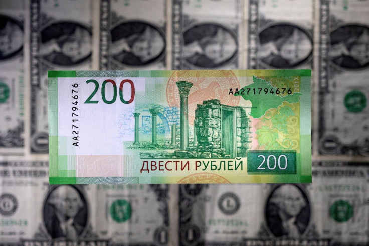 A Russian rouble banknote is seen placed on U.S. dollar banknotes in this illustration taken March 1, 2022. 