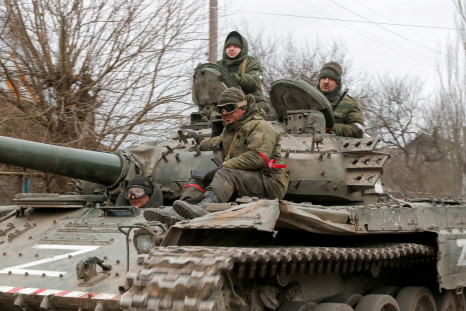 Service members of pro-Russian troops in uniforms without insignia are seen atop of a tank with the letter "Z" painted on its sides in the separatist-controlled settlement of Buhas (Bugas), as Russia's invasion of Ukraine continues, in the Donetsk region,