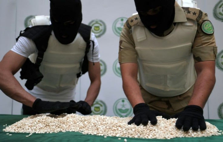 Officers with the Directorate of Narcotics Control of Saudi Arabia's Interior Ministry sort through tablets of Captagon seized during a special operation and shown to AFP afterwards in the Red Sea coastal city of Jeddah