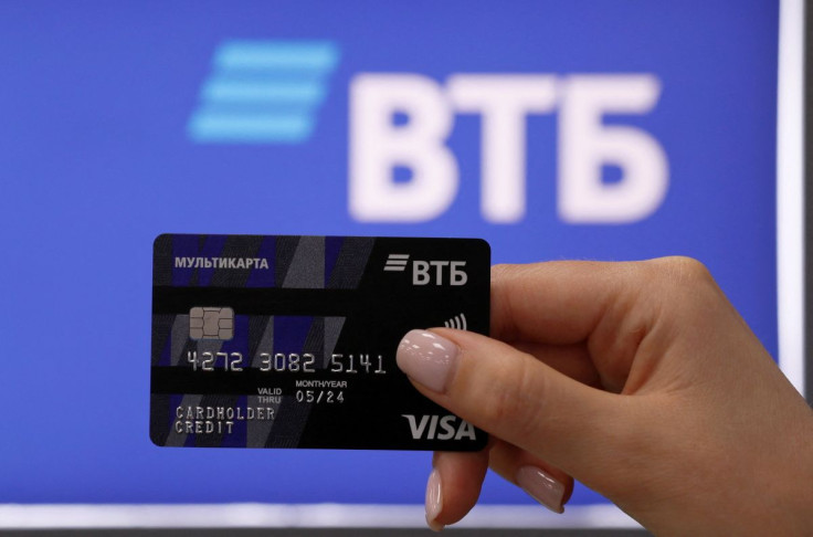 An employee poses for a picture while demonstrating a payment card at a branch of VTB bank in Moscow, Russia May 30, 2019.