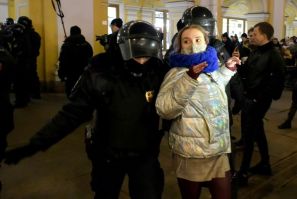 Police officers detain a woman during a protest against Russia's invasion of Ukraine in Saint Petersburg