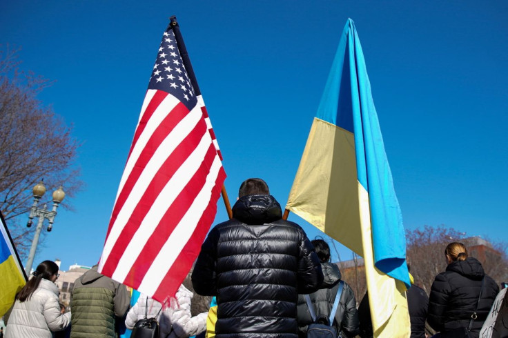 A demonstrator holds U.S. and Ukrainian flags during a "Stand with Ukraine" rally against the Russian invasion of Ukraine, in front of the White House in Washington, U.S., February 28, 2022.