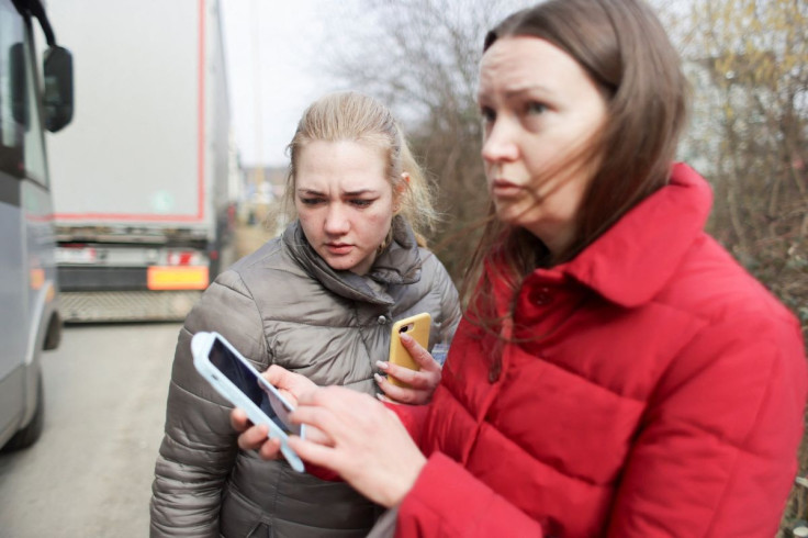 Nastia Kiselyova and Victoria Pasichnyuk, who fled the Russia's invasion in Ukraine, use smartphones near the Ukrainian-Slovakian border in Vysne Nemecke, Slovakia March 3, 2022. 
