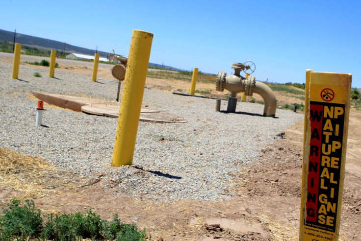 A natural gas piping is seen as a sign warns of underground natural gas pipelines outside Rifle, Colorado, June 6, 2012.  