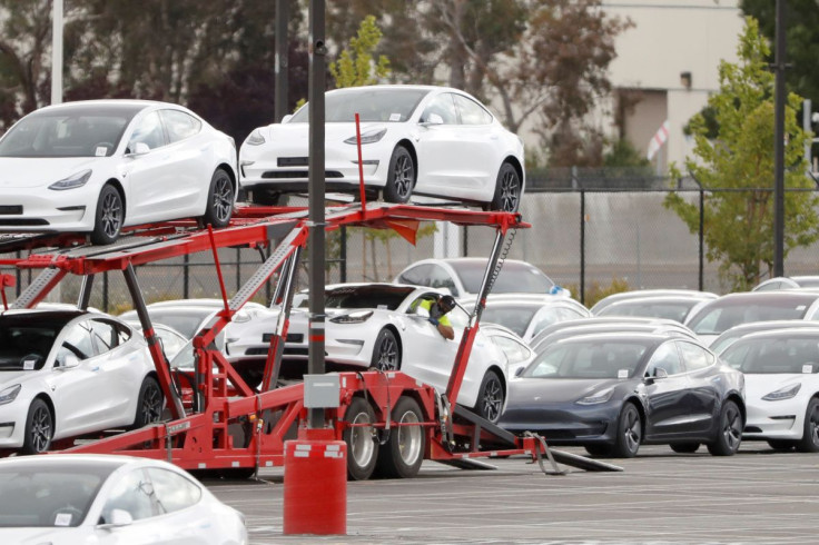 A worker loads a Tesla electric vehicle onto a car carrier trailer at Tesla's primary vehicle factory after CEO Elon Musk announced he was defying local officials' coronavirus disease (COVID-19) restrictions by reopening the plant in Fremont, California, 