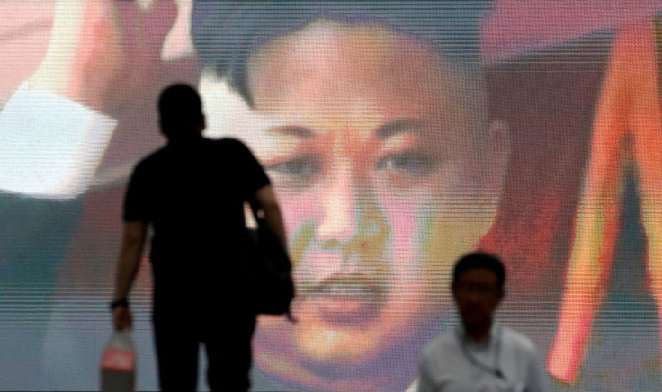 Men walk past a street monitor showing news of North Korea's intercontinental ballistic missile test in Tokyo, Japan, July 4, 2017.