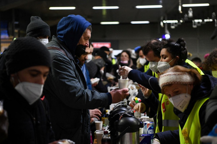 A volunteer hands over a beverage to a man, as a train from Poland arrives at Berlin's central train station, following Russia's invasion of Ukraine, in Berlin, Germany, March 3, 2022.