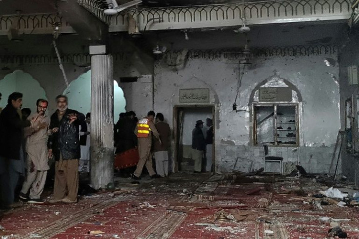 Security personnel inspect the inside of the mosque where a suicide attack killed at least 30 people