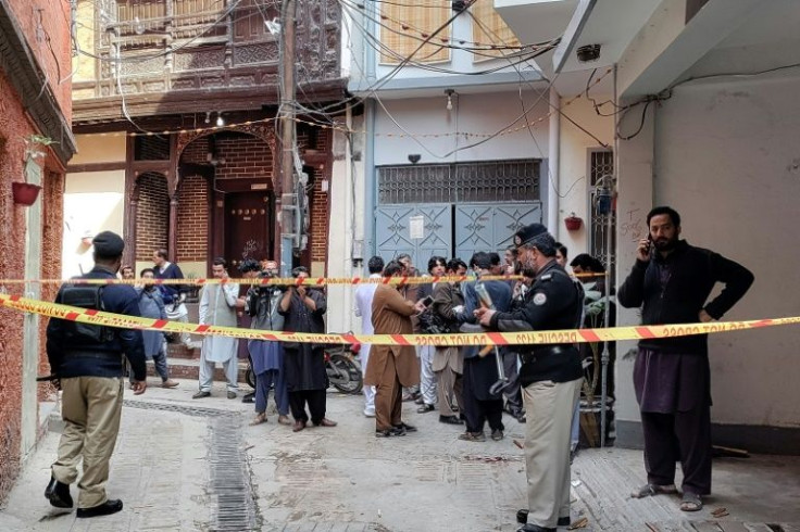 Policemen cordon off a street leading to a mosque after a deadly bomb blast in Peshawar