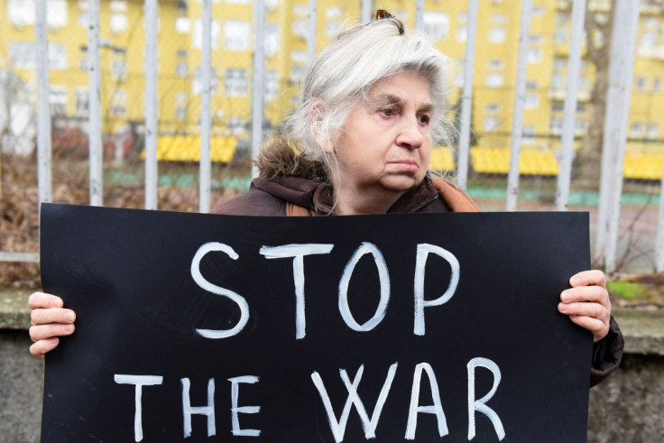 A member of the anti-war organization "Women in Black" holds a placard in front of the Russian Embassy during a protest against the Russian invasion of Ukraine, in Belgrade, Serbia, March 1, 2022.
