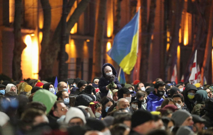 Demonstrators gather in front of a screen to watch the broadcast of the live speech of Ukraine's President Volodymyr Zelenskiy during an anti-war rally in Tbilisi, Georgia, March 4, 2022. 