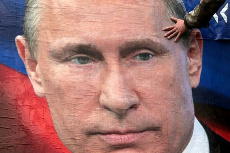 A man finishes glueing huge placards of Russian President Vladimir Putin in the city centre of Simferopol, Crimea, on March 4, 2022. The US embassy said the strike against a nuclear plant in Ukraine was a possible 'war crime'