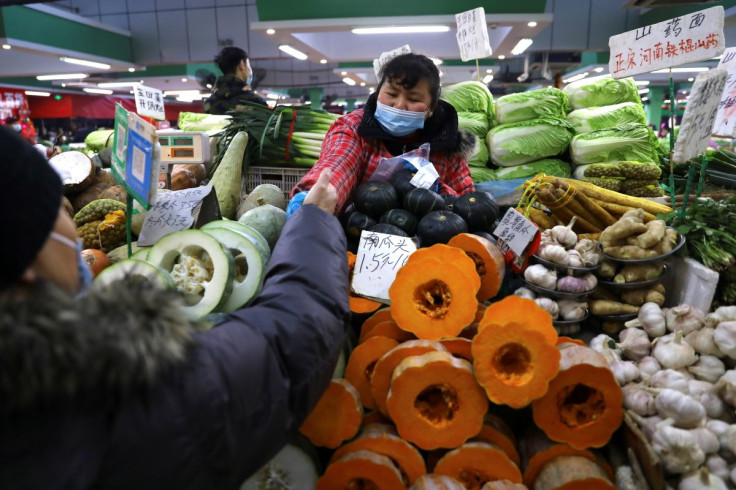 A customer buys vegetables at a stall inside a morning market in Beijing, China January 14, 2022.