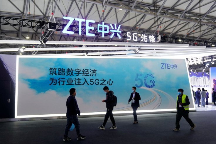 People walk past a ZTE Corp booth at the Mobile World Congress (MWC) in Shanghai, China February 23, 2021. 
