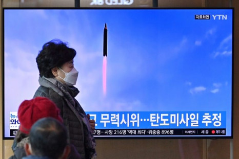 People watch a news broadcast with file footage of a North Korean missile test, at a railway station in Seoul on March 5, 2022