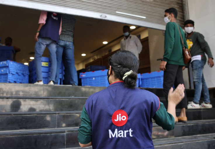 A woman wearing a Reliance JioMart vest instructs workers as they stock their products inside a Future Retail's closed Big Bazaar retail store in Mumbai, March 2, 2022. Picture taken March 2, 2022.