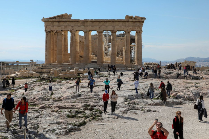 People visit the ancient Parthenon Temple atop the Acropolis hill archaeological site in Athens, Greece, February 26, 2022.